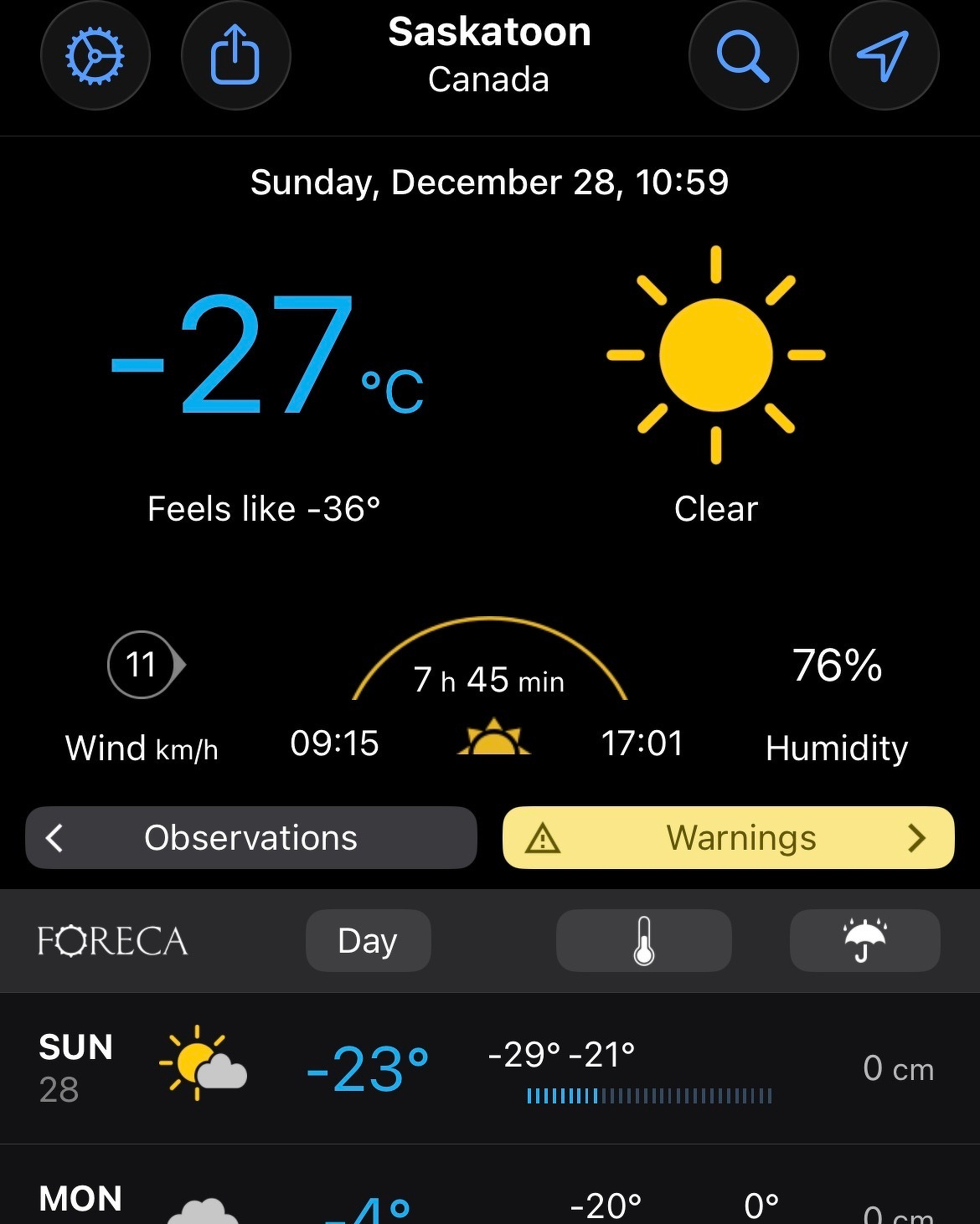 A weather app displays Saskatoon's temperature as -27°C, feeling like -36°C with clear skies.